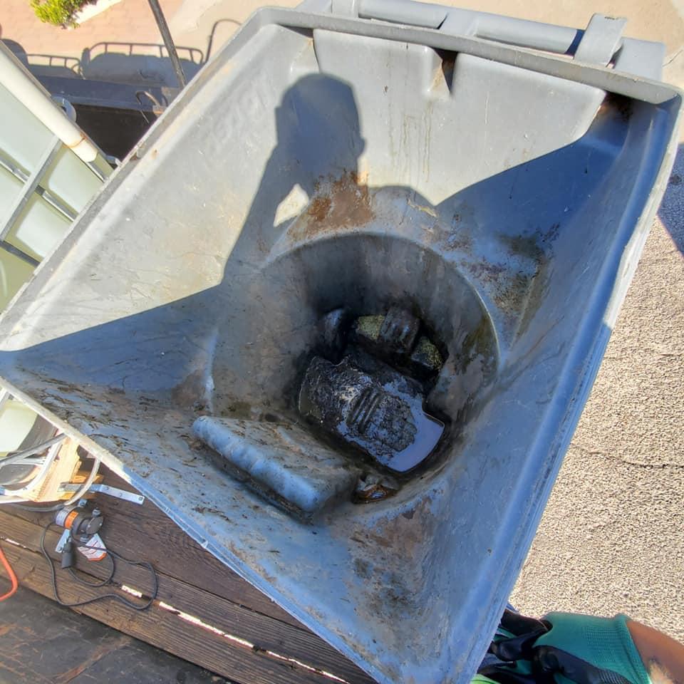 Overflowing outdoor trash bins before cleanup service.