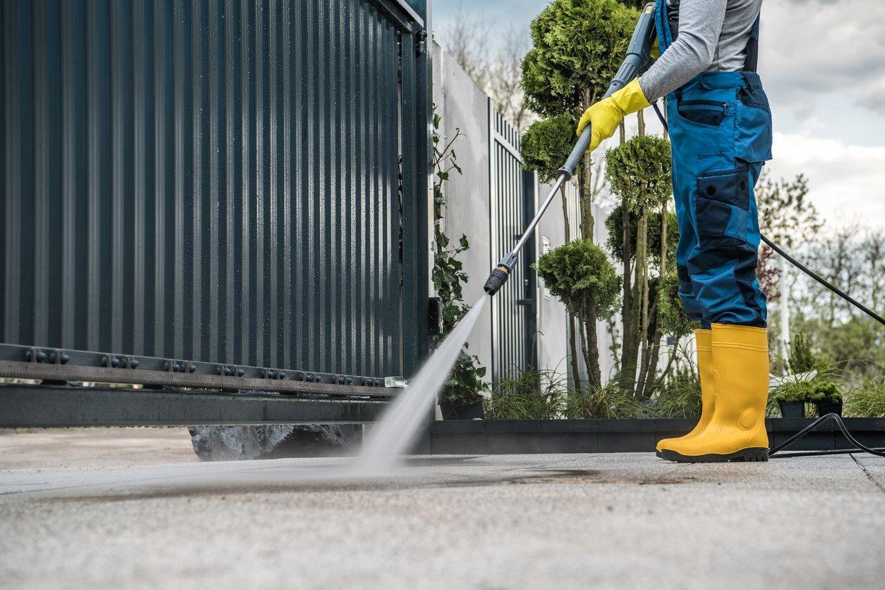 Pressure washing a concrete driveway to remove years of dust and stains.